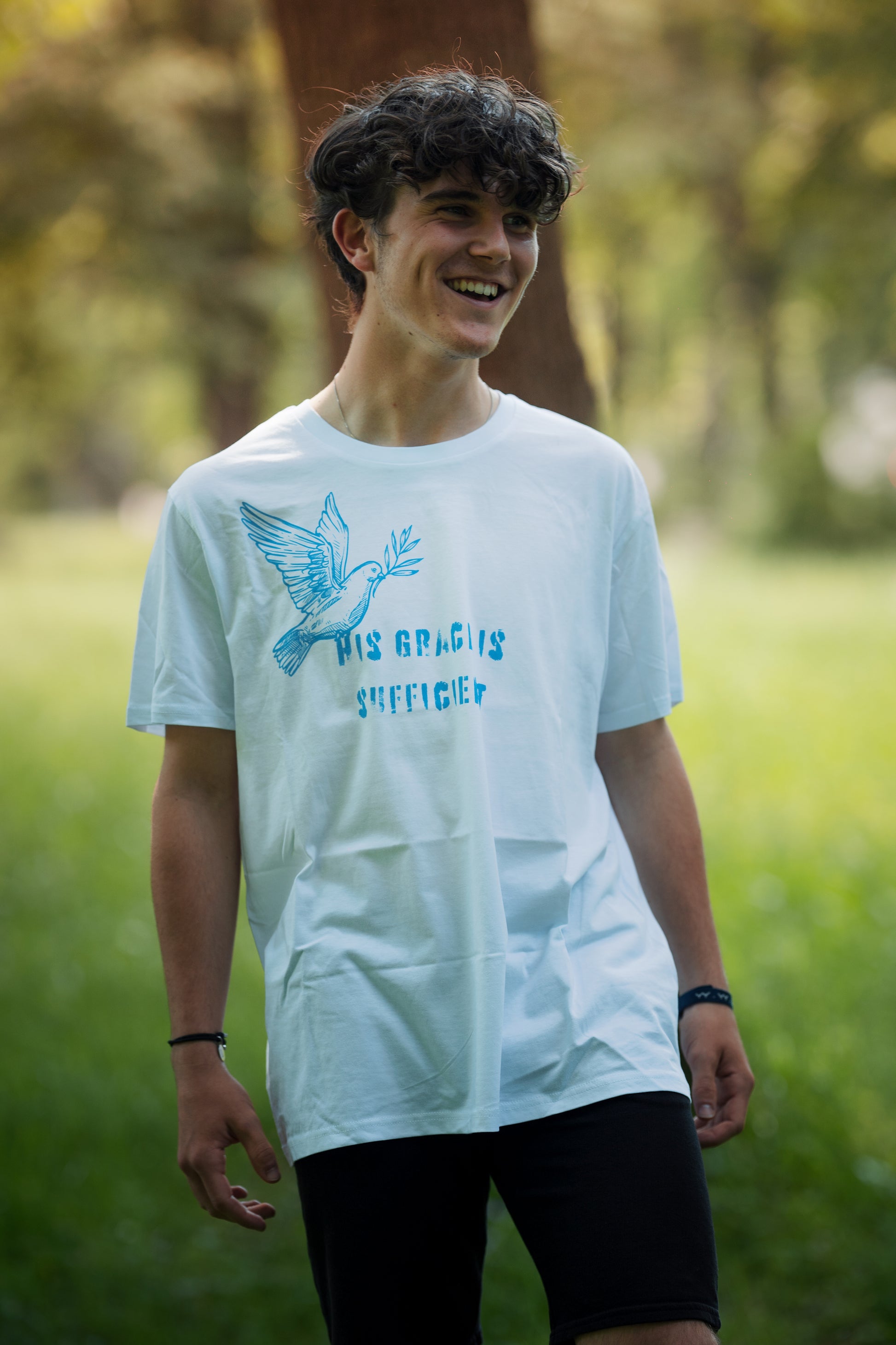 christliches T-Shirt mit einem Unisex-Schnitt in weiß an einem Model aus 100 % Bio-Baumwolle "His grace is " mit dem Schriftzug " His grace is sufficient " und einer Taube mittig auf der Brust. Erhältlich in den Größen S bis XXL und in weiteren Farben