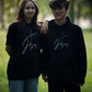 christliches T-Shirt und Hoodie mit einem Unisex-Schnitt an 2 Models in schwarz aus Bio-Baumwolle "Kreuz Jesus" mit einem Kreuz und dem Schriftzug Jesus mitten auf der Brust. Erhältlich in den Größen S bis XXL