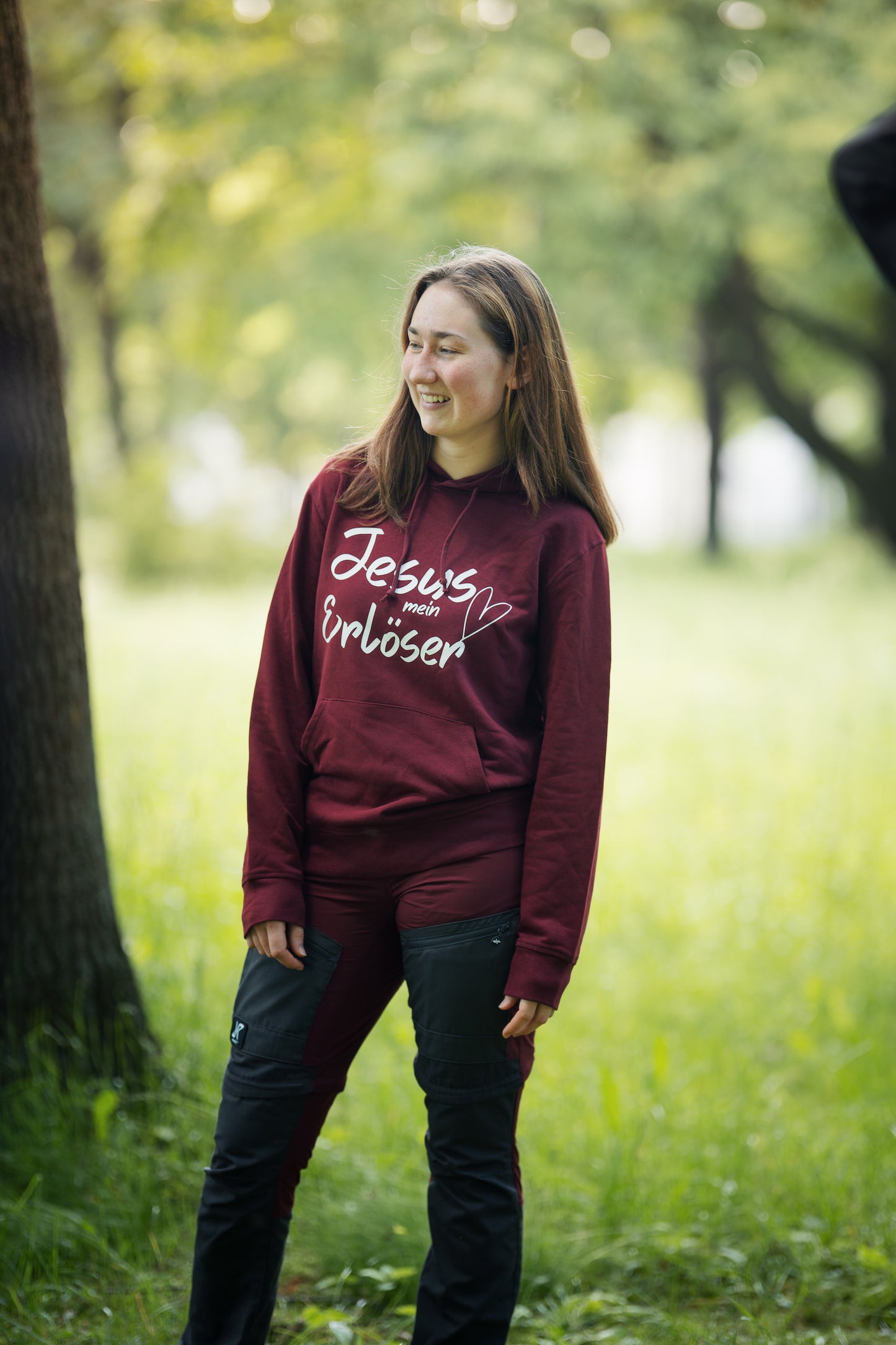 Ein Model mit einem dunkelroten Hoodie "Jesus mein Erlöser" .