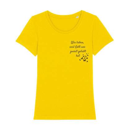 christliches T-Shirt mit einem Frauen-Schnitt in gelb aus 100 % Bio-Baumwolle "Wir lieben weil Gott uns zuerst geliebt hat" rechts auf der Brust. Erhältlich in den Größen XS bis XXL